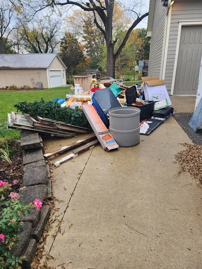 Dumpster being loaded with debris for Estate Cleanout Dumpster Rental in Big Lake